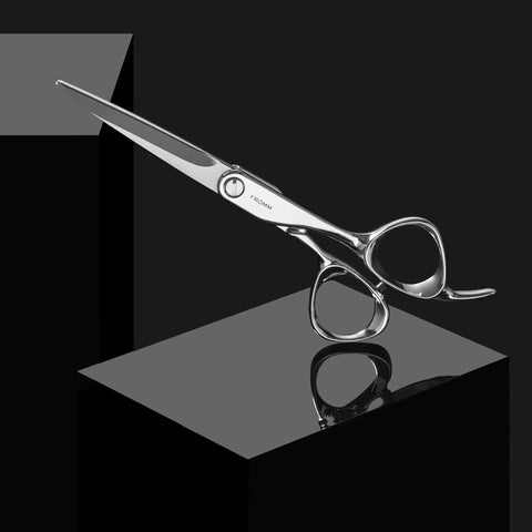 Polished Silver Japanese Steel Hair Cutting Shears With Beveled Blade For Wet And Dry Hair displayed on a reflective surface.