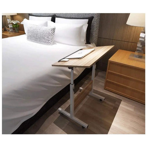 Heavy Duty Rolling Laptop Desk With Secure Locking Brake Casters Adjustable Mobile Workstation Table For Bed Sofa Living Room Home Office Gaming Lounge Setup placed beside a bed.