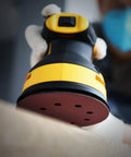 Top Shelf 25 Pack Five Inch Eighty Grit Sanding Discs With Hook And Loop Backing for random orbital sander in use.