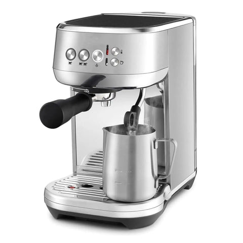Silver coffee machine steaming milk, showing front view with portafilter and stainless steel milk jug.