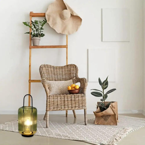 Battery Powered Table Lamp Cordless LED Lantern with handle on floor near wicker chair, amber-green glass shade visible