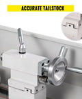Mini metal lathe with white housing and large silver handwheel, side view.