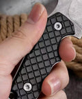 Close-up of hand gripping Mini Survival Knife With Sheath, Back Clip Whistle, And Multi Tool Build handle