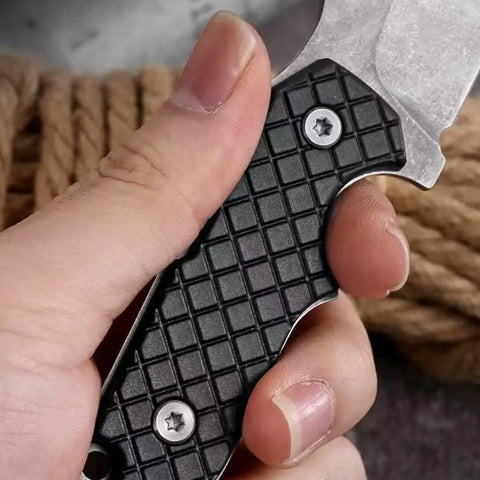 Close-up of hand gripping Mini Survival Knife With Sheath, Back Clip Whistle, And Multi Tool Build handle