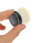 Super Sleek Four Pack Retractable Spring Loaded Cabinet Knobs with black zinc alloy, held in hand for smooth operation.