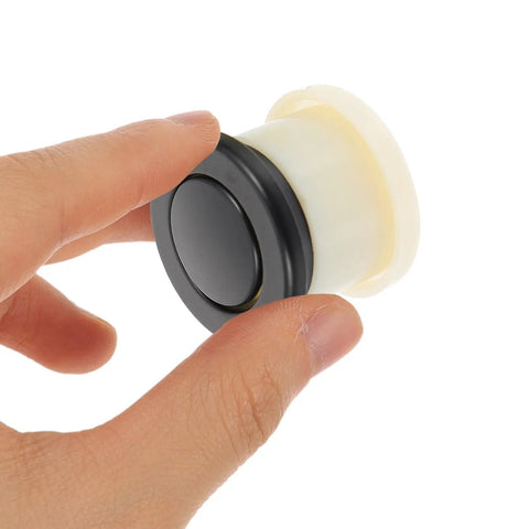Super Sleek Four Pack Retractable Spring Loaded Cabinet Knobs with black zinc alloy, held in hand for smooth operation.