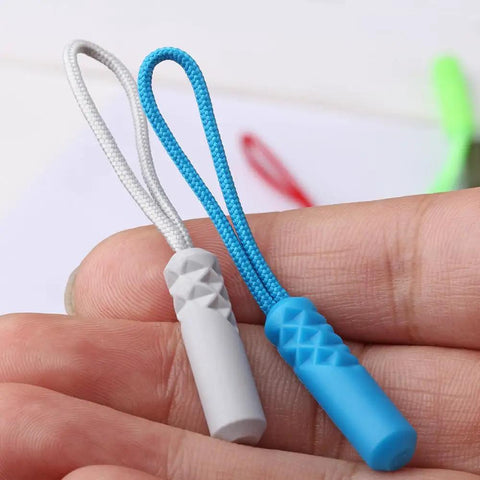 Close-up of On The Go Zipper Repair Rope Grab And Go Quick Fix For Broken Zippers, showing blue and gray cord pullers.