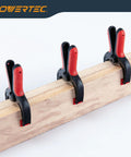 10 Pack Mini Spring Clamps with 1 Inch Opening and Pivoting Jaw Pad on a Wooden Plank
