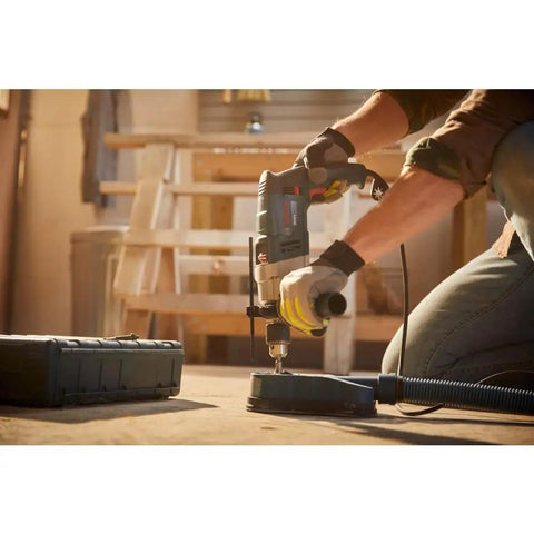 Worker using Two Speed Hammer Drill With 8.5 Amp Motor, Auxiliary Handle With Built-In Depth Gauge, And Slip Clutch for drilling