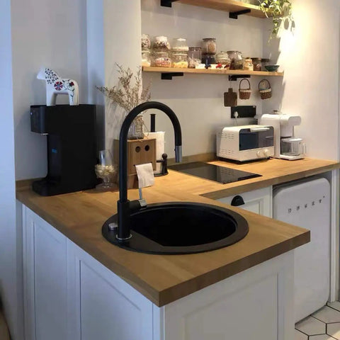 Modern kitchen with wooden countertop, black faucet, appliances, and shelves with jars. Showcases kitchen decor and organization.