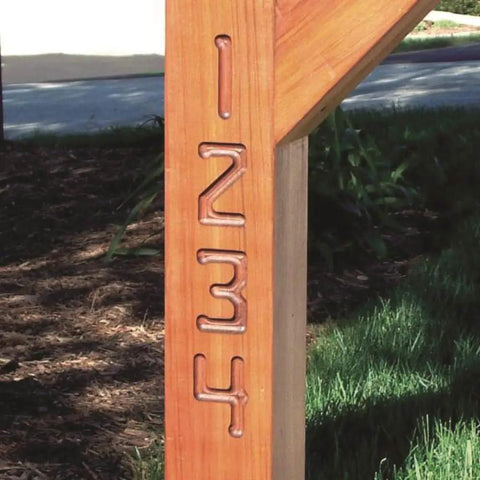 Knockout Sign Making Kit For Router Stencils cut number designs 1 to 4 on a wooden post, showcasing clean routes in hardwood.