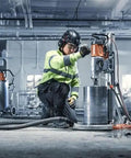 Worker using Straight Up Kickass Core Drill And Stand With 4.29 Hp Motor Three Speed Gears in a construction site.