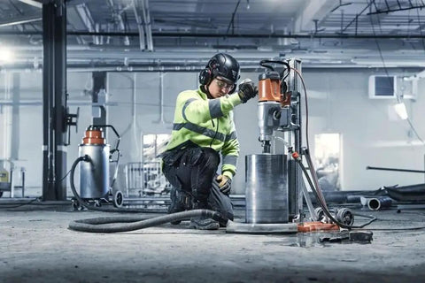 Worker using Straight Up Kickass Core Drill And Stand With 4.29 Hp Motor Three Speed Gears in a construction site.