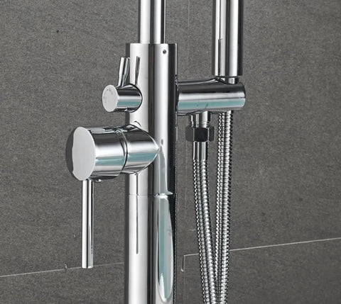 Close-up of floor mounted chrome bath tub faucet for clawfoot tubs with diverter knob and handheld shower hose attachment.