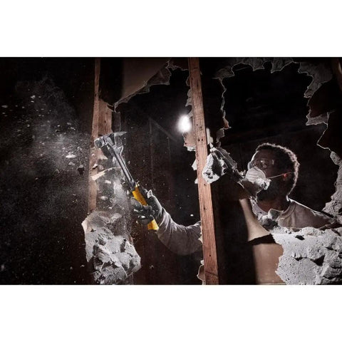 Worker using ToughSeries 22 Oz Demo Hammer With Magnetic Nail Starter Extended Claw in demolition, breaking through wall.