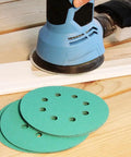 Get 100 Piece Of 5" Sanding Discs With Hook & Loop Back For Wet And Dry Work Featuring 16 Grits From 40 To 1500 Using Premium Silicon Carbide And Zirconium For Heavy Duty Smoothing Jobs That Will Not Clog Or Wear Out Too Fast. Close-up of sanding discs in use.