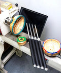 Side view of four carbide-tipped woodturning tools with black handles on a wood lathe