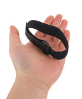 Hand holding one black strap from Sectional Couch Connector Straps 30 Pack With Hook And Loop Fasteners To Keep Modular Sofas Stable For Home And Office Use Quick Connect Reusable Fastening For Easy Sofa Section Alignment.