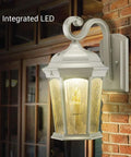 Lit Flickering Flame Lantern With Frosted Glass And Integrated Security Light 3000K Warm Glow Photocell And Motion Sensor Dusk To Dawn Outdoor Wall Lantern With Oil Rubbed Bronze Housing mounted on brick wall.