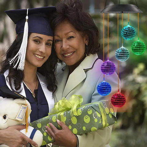 Solar Disco Ball Garden Light With Color Changing LEDs For Outdoor Patio Decor next to a graduate and woman with gift box.