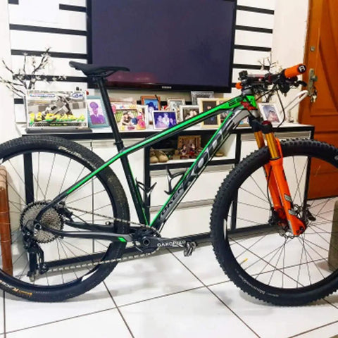 Mountain bike with 175mm MTB crankset, 30T narrow-wide 104 BCD chainring, orange suspension, in indoor setting.