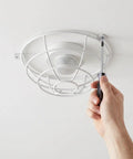 Hand installing Lockdown Fire Sprinkler Head Guard Cover Badass Heavy Duty Stainless Steel Protector Cage 7 X 2.6 Inch.