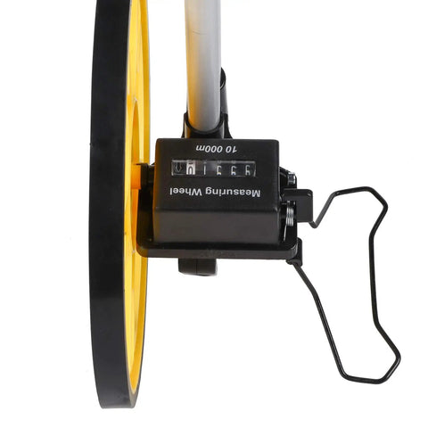 FTVOGUE Distance Measuring Wheel close-up showing yellow wheel and mechanical counter for precise measurements up to 9999.9 M.