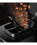 Legit Automatic Drip Coffee Maker With Built In Burr Grinder pouring coffee beans into the grinder compartment.