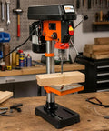 10 Inch Benchtop Drill Press With Laser Guide And Variable Speed drilling into wood on workbench with tools in background.