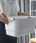 Person holding a Top Shelf White Plastic Storage Basket With Lidless Opening For Zero Fuss Organization And Straight Up Space Saving Efficiency.