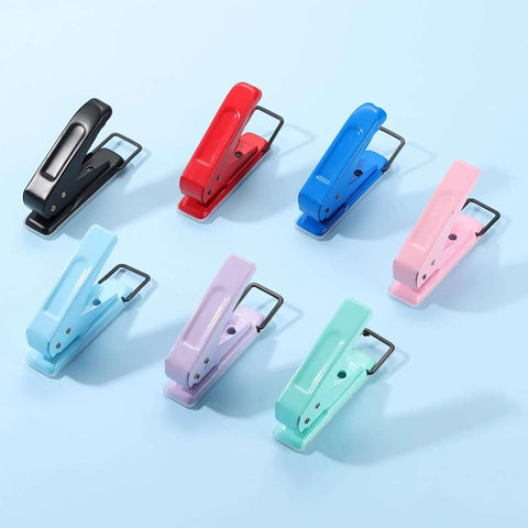 Colorful handheld paper punches on a blue background, featuring various shades including black, suitable for tags, crafts, and scrapbooks.
