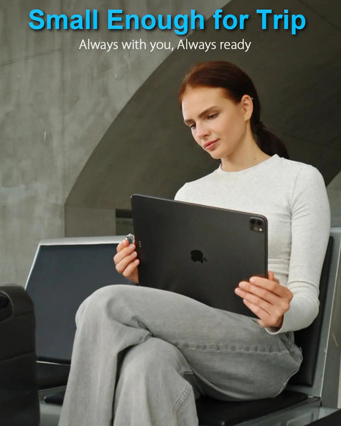 Person sitting with an iPad, highlighting the portability of Fingerprint Nano SSD 512GB External Solid State Drive Up To Four Hundred Fifty Megabytes Per Second Pocket Sized Keychain Portable Backup For iPhone iPad MacBook Steam Deck PS5 And More.