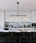 Three Light Linear Farmhouse Kitchen Island Lighting In Black And Gold Finish With Glass Shades above modern kitchen island.