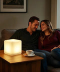 Couple enjoying cozy ambiance with Rechargeable LED Color Changing Cube Light 8 Inch Dimmable With Remote 16 RGB Colors 4 Modes Waterproof Patio Party Ambient Decorative Lamp Perfect For Home Decor And Outdoor Gatherings on table.