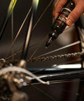 Applying Synergetic Bike Chain Lube Wet Lube 2oz Bottle With Premium Synthetic Oil And ZDDP WS2 Blend to a bicycle chain