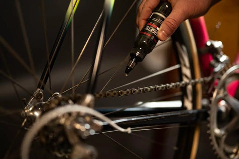 Applying Synergetic Bike Chain Lube Wet Lube 2oz Bottle With Premium Synthetic Oil And ZDDP WS2 Blend to a bicycle chain