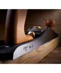 Close-up of Low Angle Jack Plane, Sweetheart No 64 Style, Old School Pro Hand Tool with ductile iron and wooden handle on wood surface.