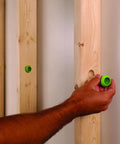 EZ Guard single-stud electrical wire protector, 5-pack; green plastic cap being installed into wooden stud; 3 visible.