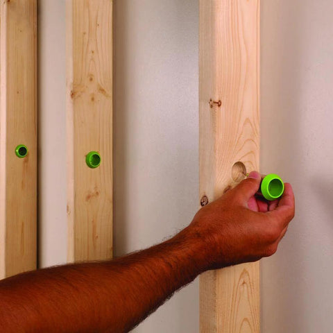 EZ Guard single-stud electrical wire protector, 5-pack; green plastic cap being installed into wooden stud; 3 visible.