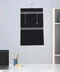 Double Sided Felt Hanging Jewelry Organizer Bag Built To Carry All Your Necklaces And Rings Slick Travel Case with necklaces hung on wall.