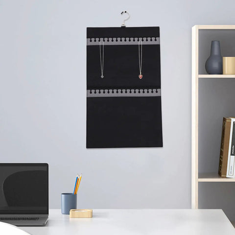 Double Sided Felt Hanging Jewelry Organizer Bag Built To Carry All Your Necklaces And Rings Slick Travel Case with necklaces hung on wall.