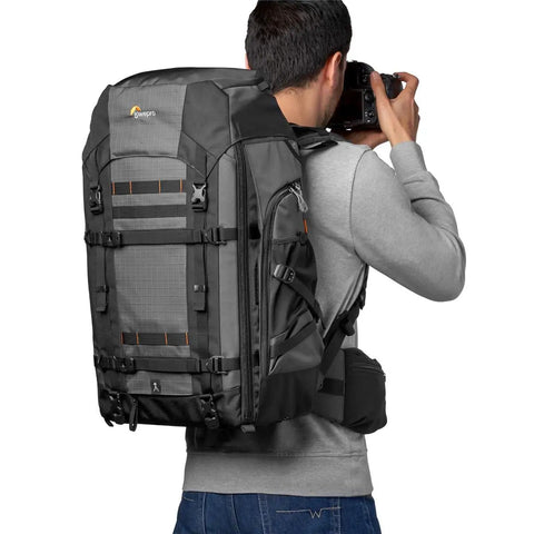 Photographer wearing Pro Trekker BP 550 AW II Backpack for Pro Photogs and On The Go Travelers, black modular gear system.