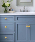 Luxury Solid Real Unlacquered Brass Cabinet Knobs Handmade Heavyweight Builds on blue bathroom vanity with sink.