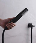 Hand holding Matte Black Rainfall Shower System With 8 Inch Shower Head Silicone Nozzles For Easy Calcium Build Up Clean Hard Water Friendly