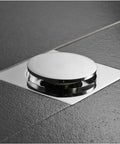 Ridiculously Durable Chrome Plated Brass Pop Up Floor Drain Plug For Bathtubs And Showers installed on dark tile floor.