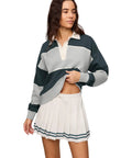 Women's Study Break Polo Sweatshirt In Feather Gray, 100 Percent Cotton With Yarn Dyed Stripe, Collared Polo Neck, Long Sleeves, Cozy Yet Polished Layer For Everyday Comfort And Effortless Style. Model wearing feather gray and dark green striped polo sweatshirt, front view
