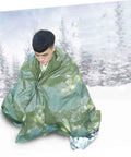 Person wrapped in reflective thermal blanket from Three Piece Camping Survival Kit With Reflective Thermal Emergency Blanket And First Aid Gear