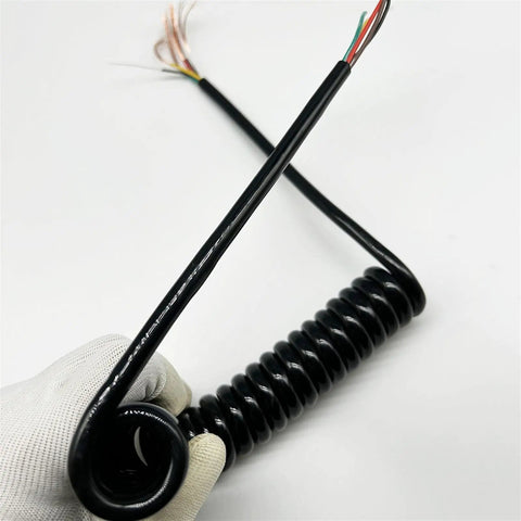 Slick Black Braided Expandable Power Cord With Coiled Spring Design offers auto-retracting action, showcased in a hand.