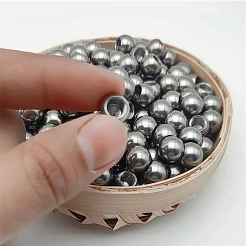 Close-up of stainless steel M6 threaded ball with drilled hole; silver spheres in a wooden bowl (set).