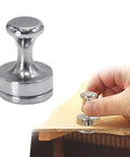 Hand holding Acoustic Guitar Panel Repair Magnet With Handle For Cracked Panel Fixes, metal tool on wooden surface